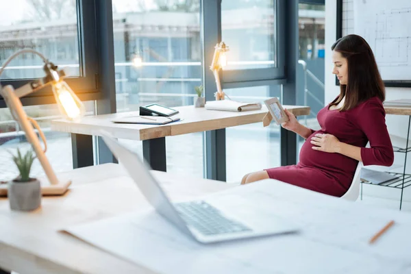 Mujer agradable sosteniendo una foto en la mano — Foto de Stock