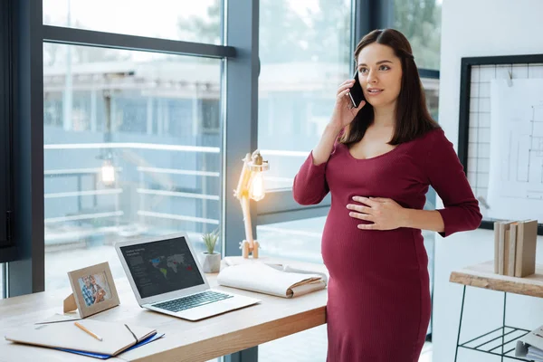 Mujer embarazada concentrada en la conversación — Foto de Stock