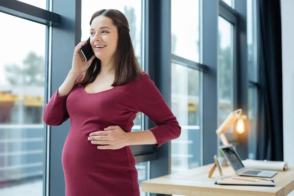 Cintura para arriba de la mujer embarazada encantada con teléfono móvil — Foto de Stock