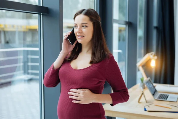 Mujer embarazada alegre mirando hacia otro lado — Foto de Stock