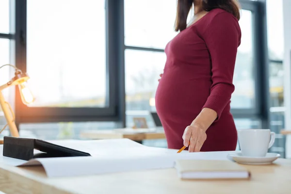 Крупный план беременной женщины на работе — стоковое фото