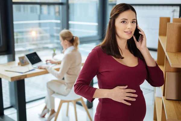 Mujer embarazada hablando en la oficina — Foto de Stock