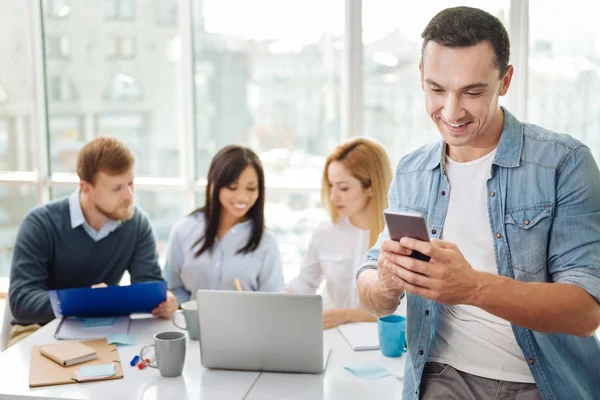 Schöner Mann schaut auf sein Telefon — Stockfoto