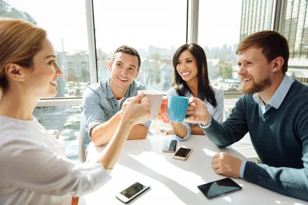 Fröhliche Menschen, die ihre Tassen berühren — Stockfoto