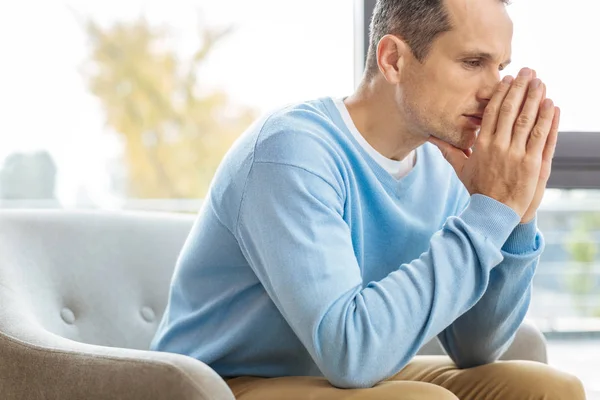 Hombre sosteniendo sus manos juntas — Foto de Stock