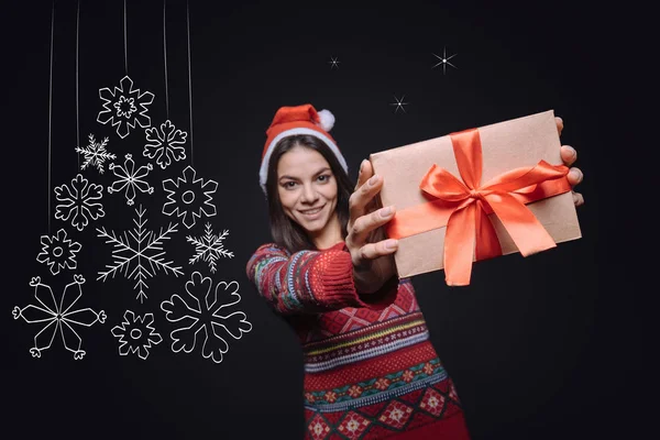 Happy young woman showing the box with a Christmas present — Stock Photo, Image