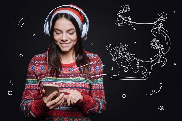 Zaangażowanych kobieta przyjemne słuchanie piosenki świąteczne — Zdjęcie stockowe