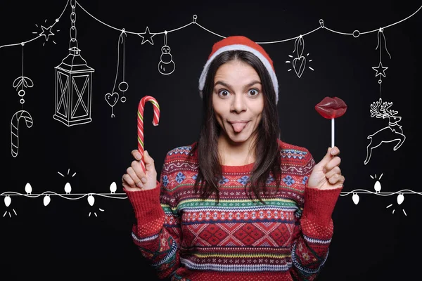 Vrolijke meisje met plezier met lollies in de studio — Stockfoto