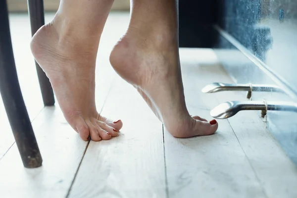Nakna kvinnliga ben stående på golv — Stockfoto