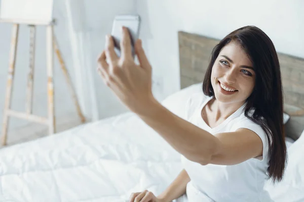 Ritratto di bruna sorridente che guarda il suo telefono — Foto Stock