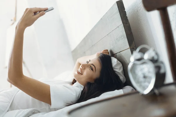 Låg vinkel foto av glad kvinna att ligga i sängen — Stockfoto