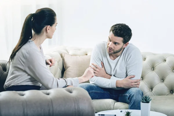 Joven guapo hablando con su terapeuta — Foto de Stock