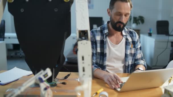 Constructeur sérieux travaillant avec un ordinateur portable — Video