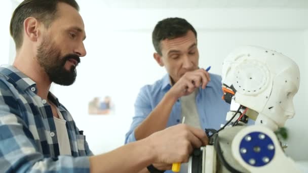 Constructores entusiastas discutiendo maqueta robot — Vídeos de Stock