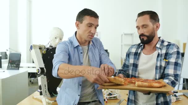 Ingénieurs expérimentés mangeant de la pizza au travail — Video