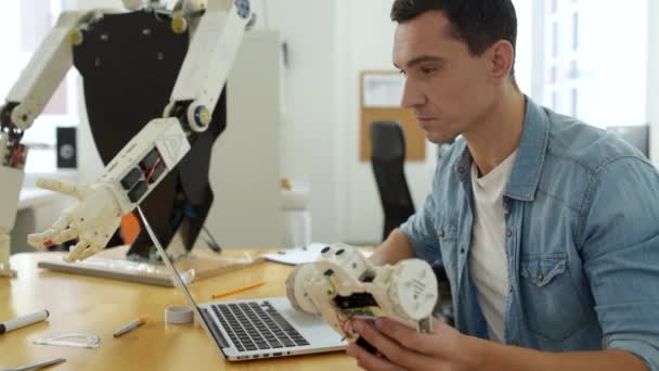 Primer plano del ingeniero diligente con pieza de robot — Vídeo de stock