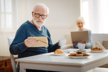 Fotoğrafa bakıp mutlu olgun erkek kişi
