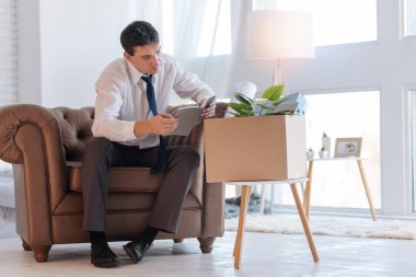 Sakin konsantre adam rahat bir koltukta otururken okuma