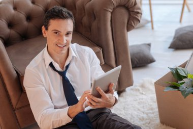 Bir tablet tutarken gülümseyen akıllı hevesli adam