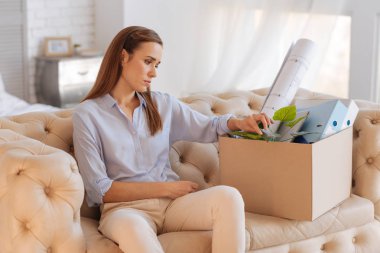 Düşünceli büyük bir kutu oturan genç kadın