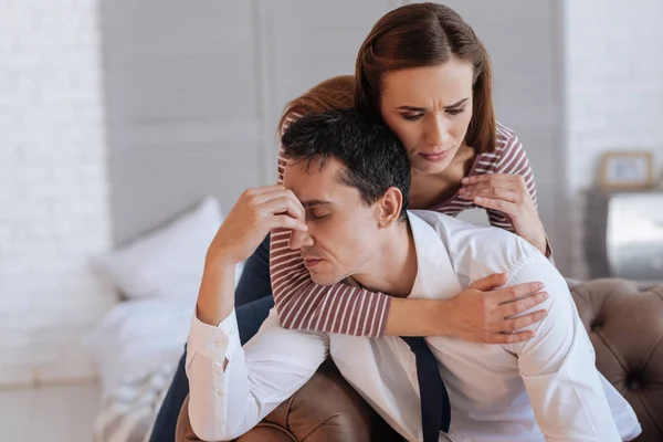Mulher amável abraçando seu marido deprimido exausto — Fotografia de Stock