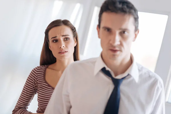 Worried kind woman looking at her irritated tired husband — Stock Photo, Image