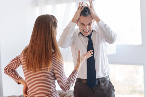 Furious irritated man rejecting to hear his angry wife