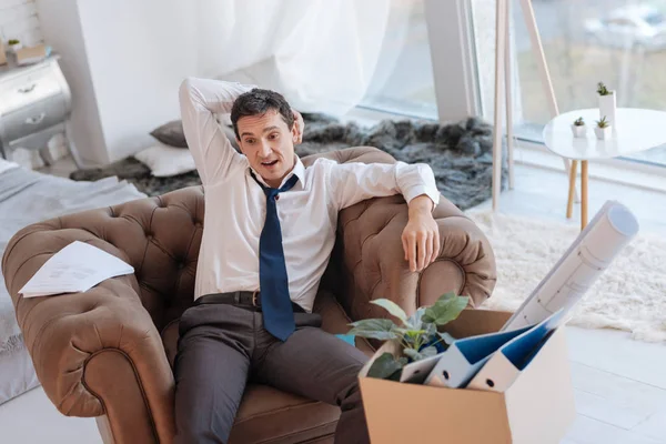 Bir koltuk bir kutu içinde onun yanında oturan duygusal adam