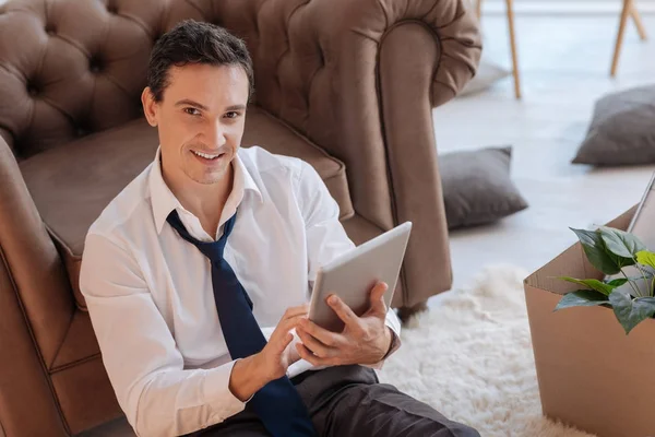 Bir tablet tutarken gülümseyen akıllı hevesli adam