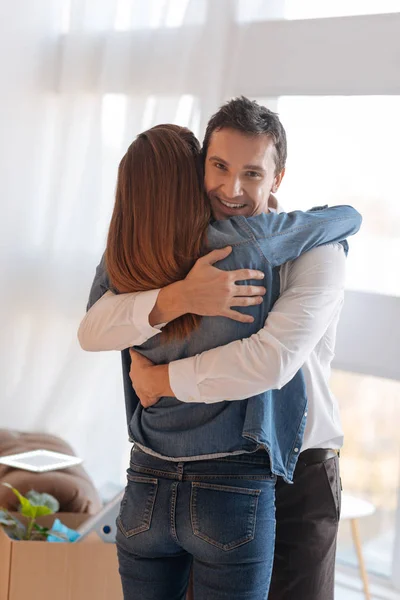 Joven hombre amable buscando feliz mientras abraza a su hermosa esposa —  Fotos de Stock