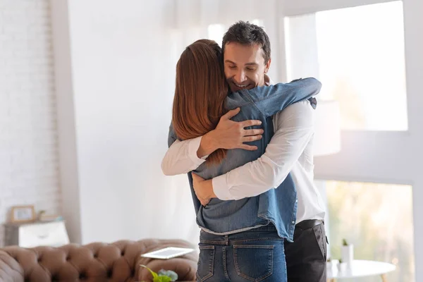 Glada känslomässiga mannen hälsning hans fru med en befordran på jobbet — Stockfoto