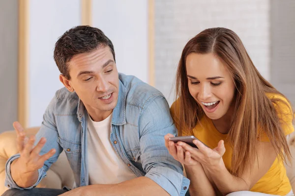 Aufgeregte junge Frau schaut auf ihr neues wunderbares Gadget — Stockfoto