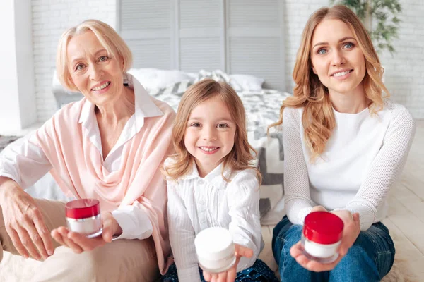 Freudig glückliche Familie zeigt Ihnen Flaschen Sahne — Stockfoto