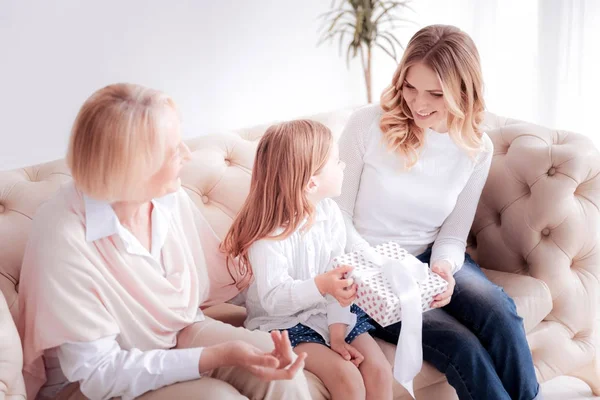 Fröhliche schöne Frau schenkt ihrem Kind ein Geschenk — Stockfoto