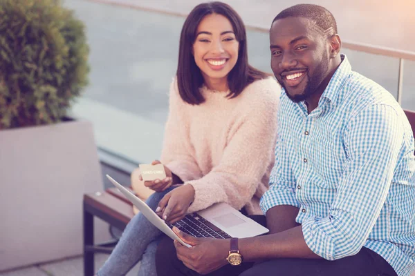 Positiv fröhliches Paar sitzt auf der Bank — Stockfoto