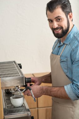 İş yerinde olurken kahve yapma neşeli genç adam