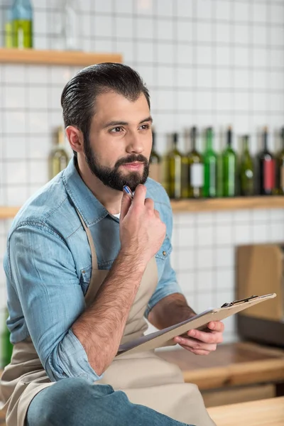 Smart Besitzer eines neuen Cafés sitzt und schaut nachdenklich während der Arbeit — Stockfoto