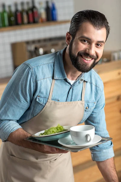 Pozitivní zodpovědné číšník s úsměvem při užívání špinavého nádobí — Stock fotografie