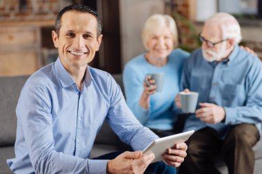 Yakışıklı adam ailesi kahve içme sırasında tablet ile poz