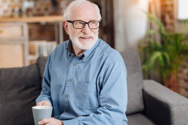 Bir fincan kahve tutan hoş yaşlı adam