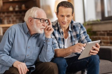 Babası için makale tablet gösteren genç adam