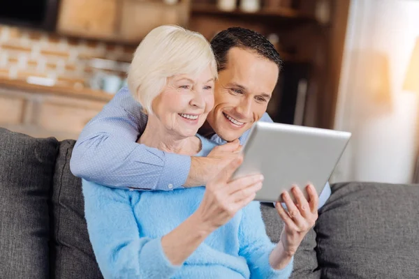 Gelukkige zoon en zijn senior moeder samen kijken naar de video — Stockfoto