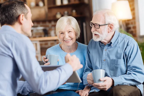 Loving son showing something on tablet to his parents — Stock Photo, Image