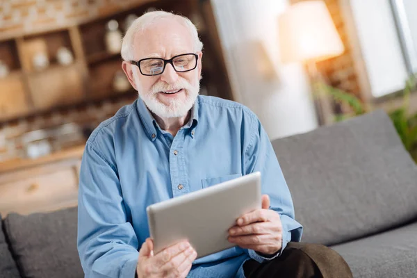 Příjemný starší muž procházení webu na tabletu — Stock fotografie
