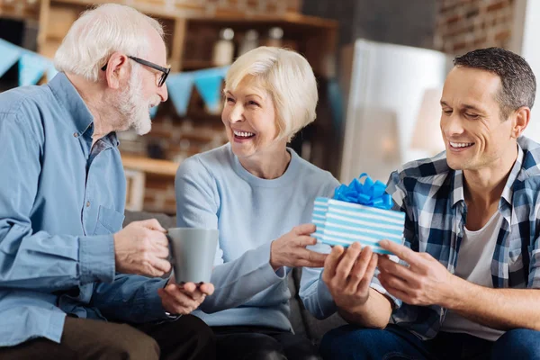 Fröhlicher Mann macht seiner betagten Mutter ein Geschenk — Stockfoto