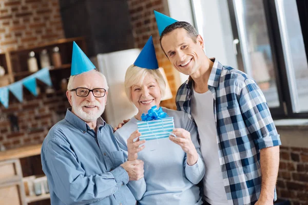 Upbeat father and son posing with mother celebrating birthday