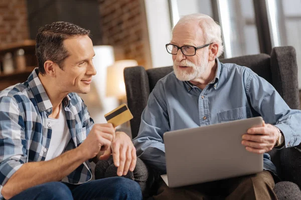 Dizüstü bilgisayar kullanarak babasının banka kartı veren genç adam