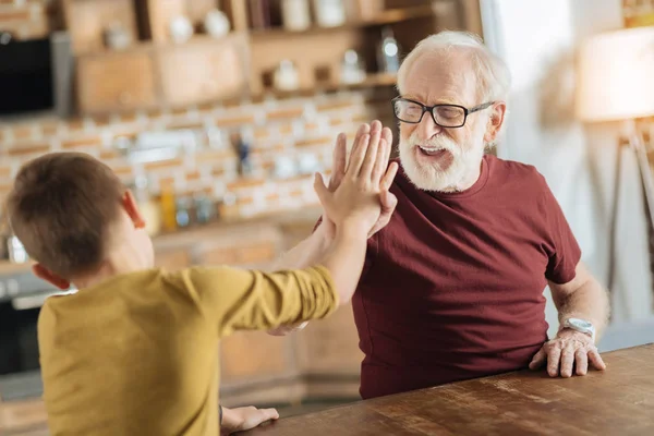 Positive joyful grandfather and grandson giving high five — Stock Photo, Image