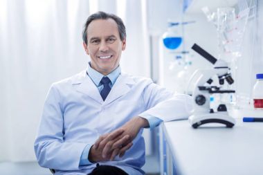 Ellerini bir arada tutan mutlu memnun doktor