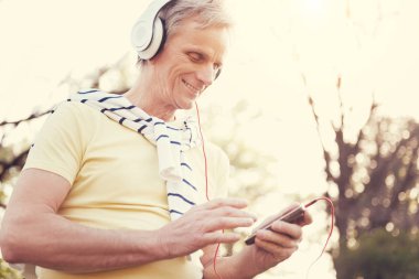 Bir Mp3 player'ı kullanarak neşeli yaşlı adam